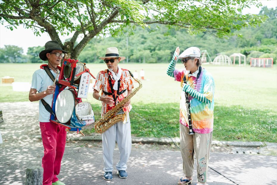 芝生広場で演奏するちんどん屋の三人組