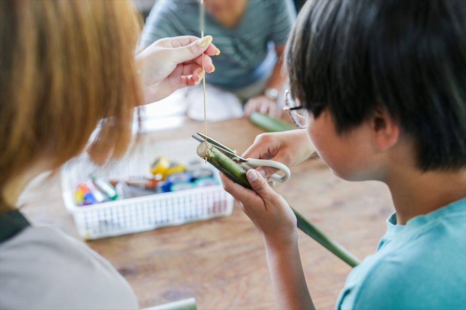 竹の水鉄砲を作る手元。たこ糸と竹を組み合わせる